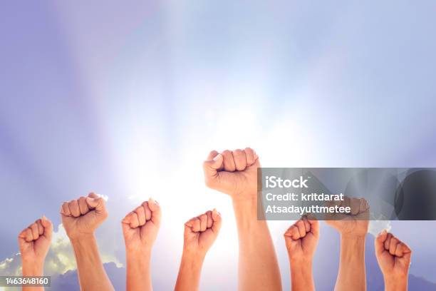 Peoples Raised Fist Air Fighting And Sunlight Effect Competition Teamwork Concept Background Space For Text Stock Photo - Download Image Now