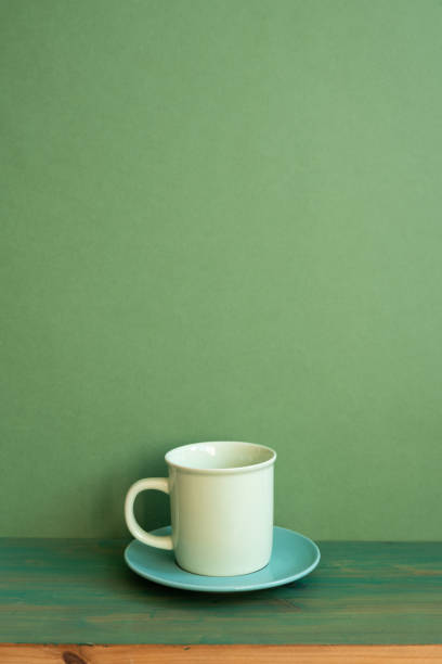 istock Coffee cup on wooden table. green wall background. minimal, copy space 1463652455