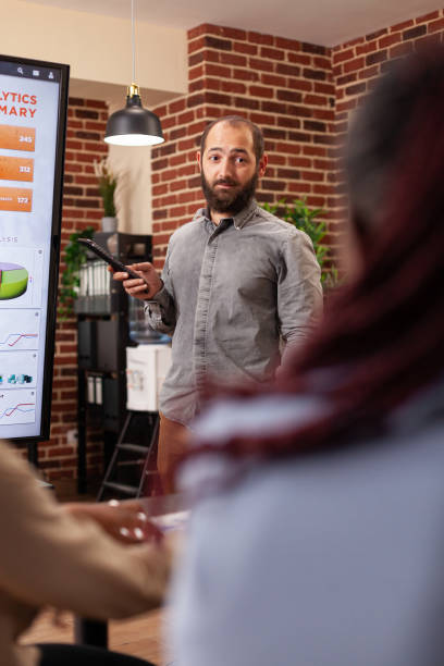 istock Entrepreneur man pointing at monitor explaining management statistics 1463652463