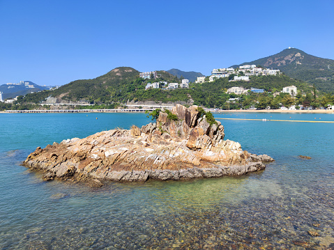 Rock formation at Deep Water Bay beach. The bay is located on the southern shore of Hong Kong Island in Hong Kong. The bay is surrounded by Shouson Hill, Brick Hill, Violet Hill and Middle Island.