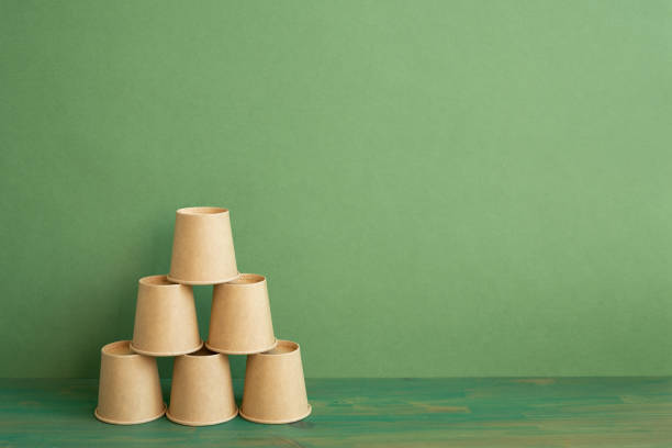 Pyramid stack of brown cup on wooden table. green background. business develop achievement growth concept stock photo