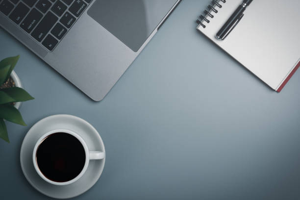 istock Coffee mugs, laptops, notepads, placed on businessman's desk, modern coworking office. copy space 1463653292