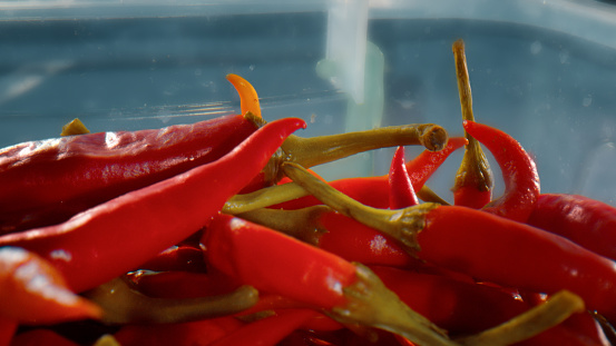 A lot of hot red chili peppers in a glass bowl