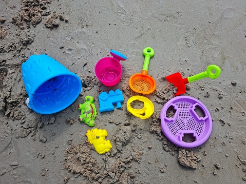 Colorful children's sand play equipment on the beach