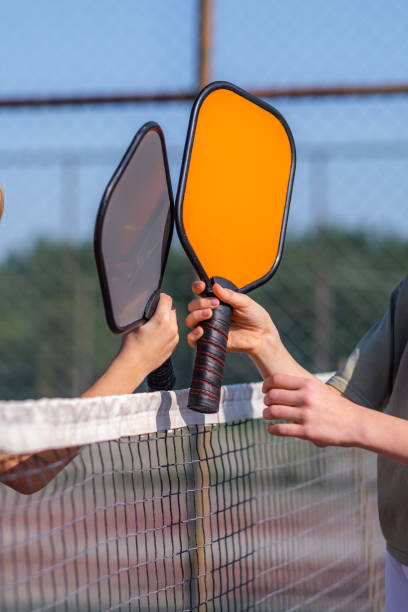 Pickleball paddles close up in children hands, leisure outdoor sport activity. stock photo
