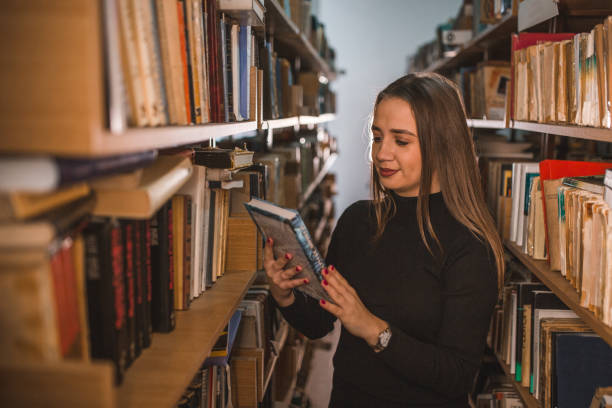 istock The librarian holds a book in her hands and decides whether to read it 1463669855