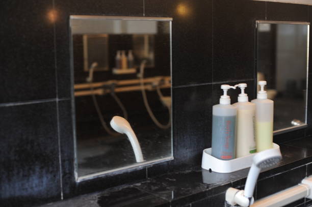 シャワー、ホース、シャンプー、石鹸ディスペンサー、鏡付きのバスルームのインテリア