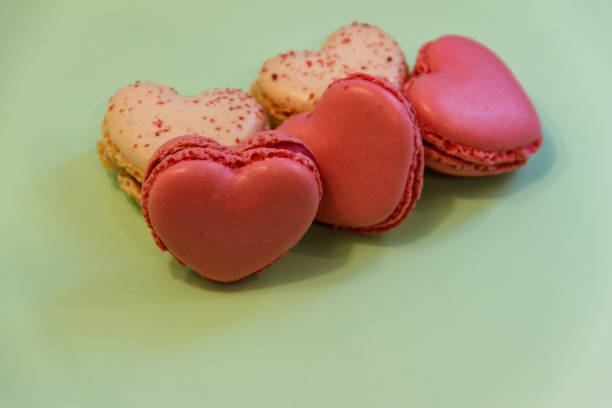 istock Sweet heart shaped macaroons on green background. Valentine Day concept 1463671766