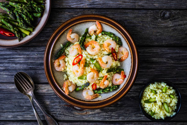 Risotto with shrimps on black wooden table