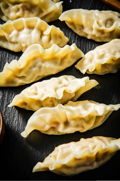 Photo of Dumplings gyoza with shrimp on a cutting board.