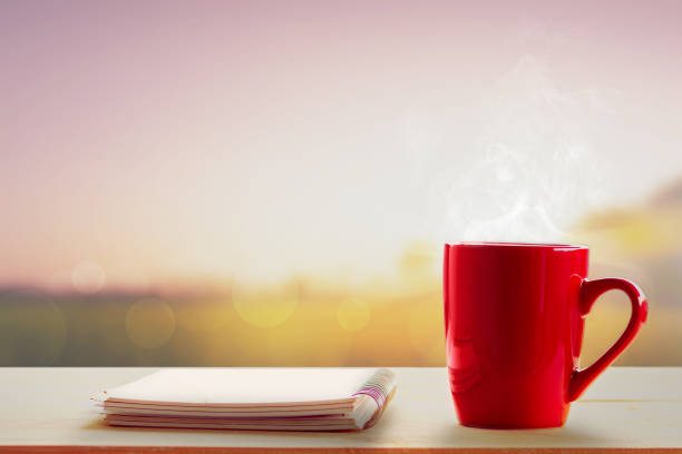 istock hot coffee and notebook on table and blurry meadows at sunrise 1463675968