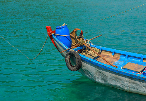 A wooden boat floating on the blue sea in summer day.