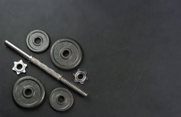 istock Disassembled metal dumbbell lies on an empty concrete background. copy space, top view 1463676773