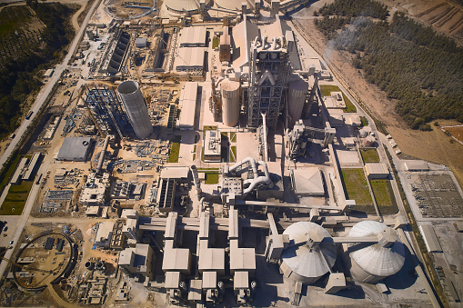 Huge cement producing plant. Aerial view of silos towers, pipes and other structures of industrial area