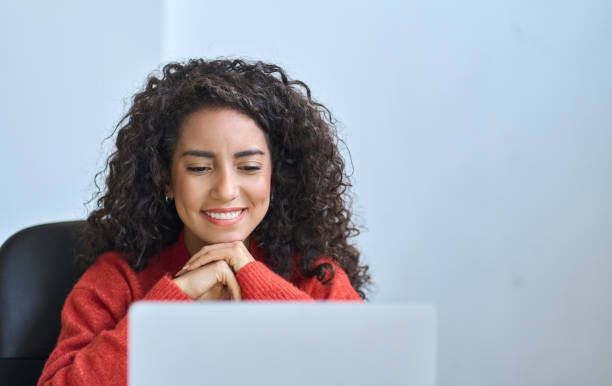 Young happy latin woman student watching online webinar elearning on laptop.