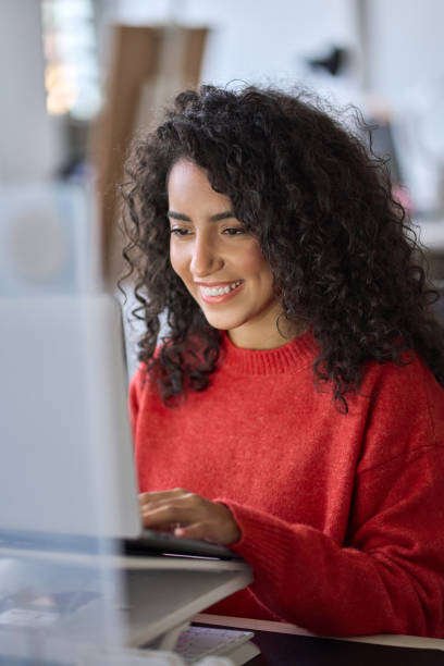istock Young happy latin woman student elearning using laptop. Vertical shot 1463681256