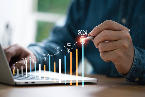 l'uomo d'affari usa la scrittura a penna elettronica aumentando il grafico colorato dal 2023 al 2024 anno di pianificazione aziendale e concetto di crescita degli investimenti azionari. - financial graph foto e immagini stock