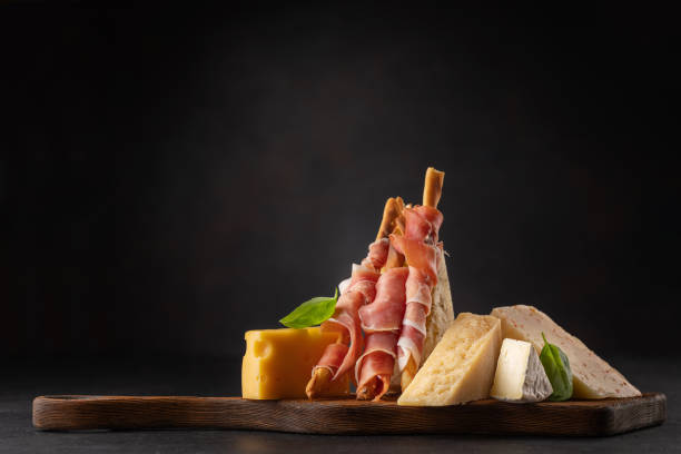 Antipasto board with various cheese and snacks Antipasto board with various cheese and prosciutto snacks prosciutto brie stock pictures, royalty-free photos & images