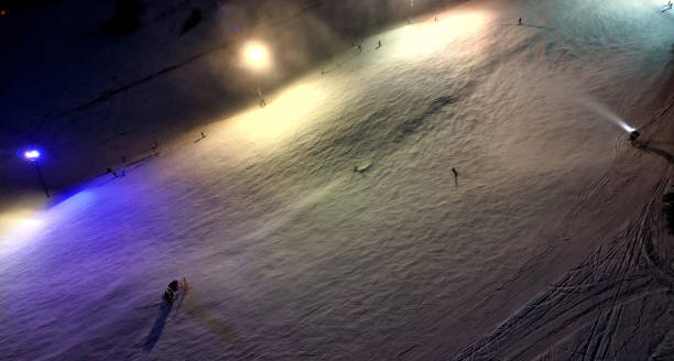 observation of skiers' behavior on the downhill track from a height. artificial snowmaking from water cannons. shoot a stream of water onto furrowed surface. expensive energy intensive technology, snow cannon, nozzle, reflektor observación del comportamiento de los esquiadores en la pista de descenso desde una altura. fabricación de nieve artificial a partir de cañones de agua. dispara un chorro de agua sobre la superficie surcada. tecnología costosa que consume mucha energí