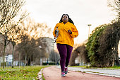 Plus size woman running in the natural park