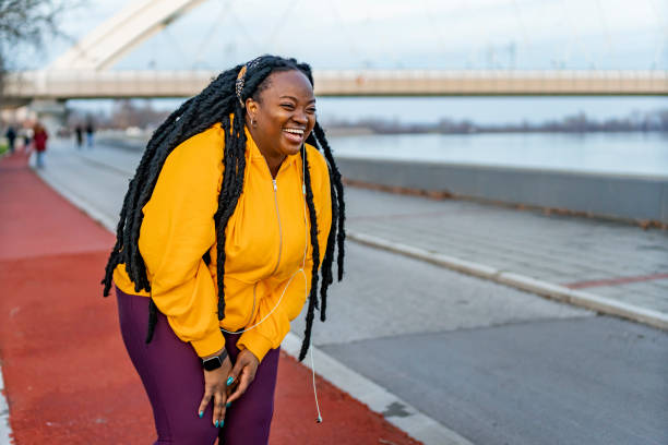 istock Young woman laughing while relaxing after running outdoors. 1463684074