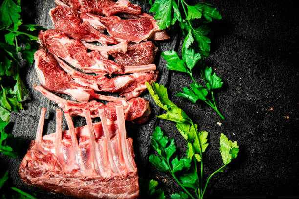 istock Fresh raw rack of lamb on a stone board with parsley. 1463692326