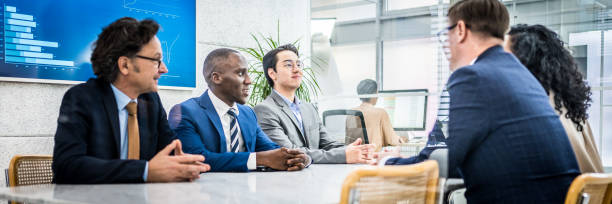 istock Diverse corporate employees sitting at conference room table 1463692374