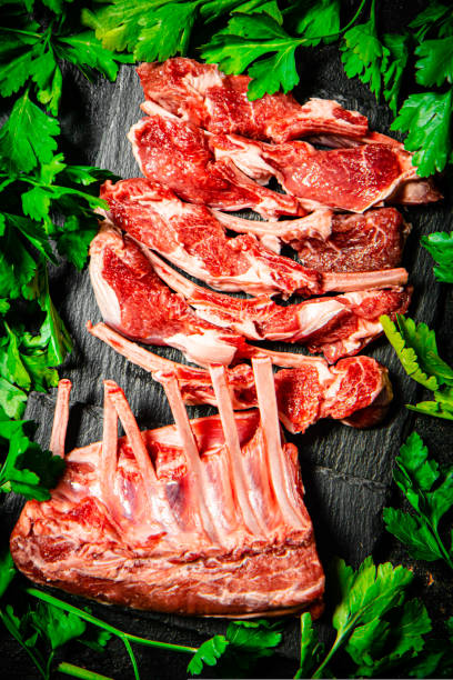 istock Fresh raw rack of lamb on a stone board with parsley. 1463694451