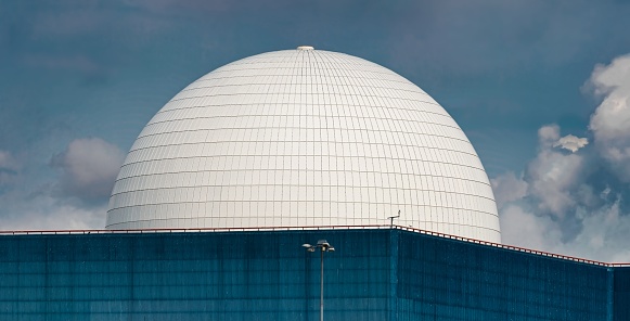 Sizewell, United Kingdom – July 28, 2022: The dome of Sizewell B nuclear power station is shown in a detailed panorama with blue sky complementing the blue wall.