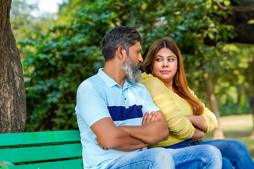 Indian couple giving angry expression at park.