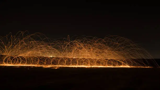 Steel wool photography at the desert rat night time with fire splash all over. Slow Shutter speed photography with steel wool