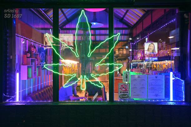 Bright neon signage of a cannabis cafe along busy Silom Road, near Sala Daeng BTS Station, Bangkok Bangkok, Thailand – January 09, 2023: In Thailand, Cannabis, known by the name Ganja was decriminalized in 2022, and weed cafes and dispensaries have since become common across the country silom stock pictures, royalty-free photos & images