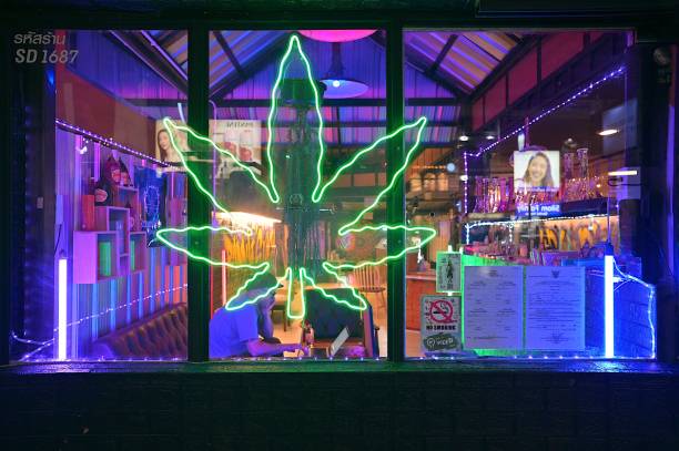 sinalização neon brilhante de um café de cannabis ao longo da movimentada silom road, perto da estação bts sala daeng, bangkok - silom - fotografias e filmes do acervo