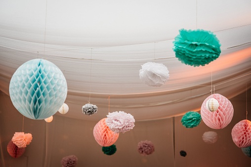 Beautiful colorful decorations hanging down from the ceiling in a wedding party