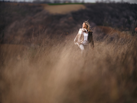 Carefree woman having fun in autumn day on a hill. Photographed in medium format. Copy space.