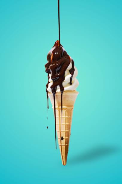 istock Vertical shot of an icecream cone with chocolate dripping on a blue background 1463708507