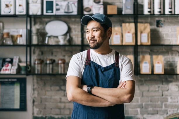 propietario japonés seguro de pie en su tostadora de café - japonés oriental fotografías e imágenes de stock