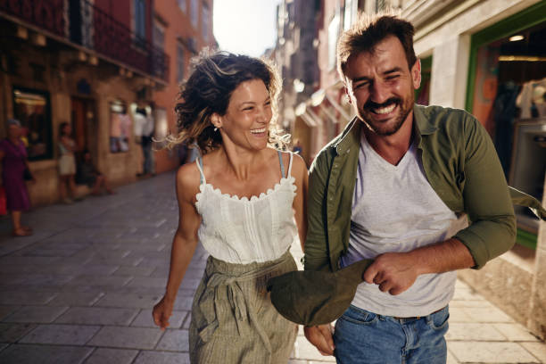 istock Playful couple having fun while running on the street. 1463712333