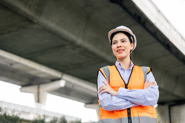 istock Asian engineer worker woman or architect looking construction with white safety helmet in construction site. Standing at highway concrete road site. Progress planning of highway bridge. 1463714952