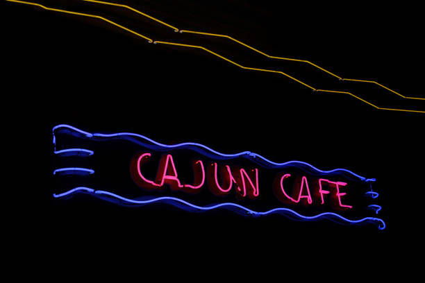 istock Glowing neon cajun cafe sign with red text and blue outline on a black background 1463715259