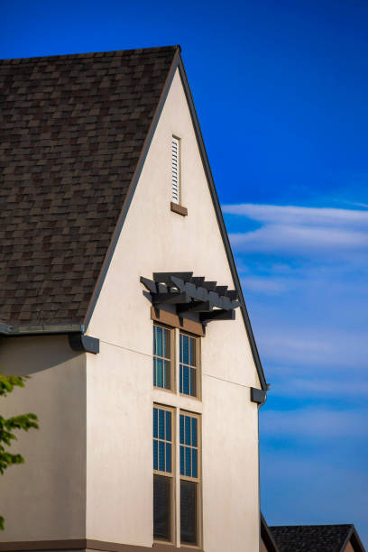 istock Rooftop of a white house with grey roof and windows under blue sky 1463716042