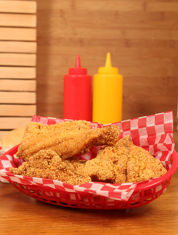 A closeup shot of fried catfish in rural cafe with mayo and ketchup bottles on the table