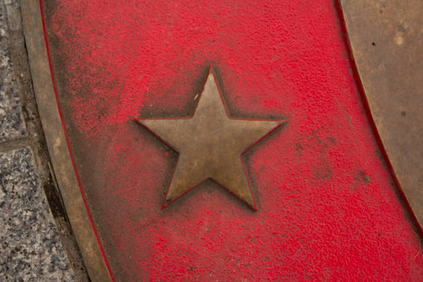 Golden five-pointed star on a red old background. Curved line. Arc. Strict Soviet style. Military rusty bronze symbol. Rank. Defender of the Fatherland Day. Tarot cards. Astrology. Reward for glory