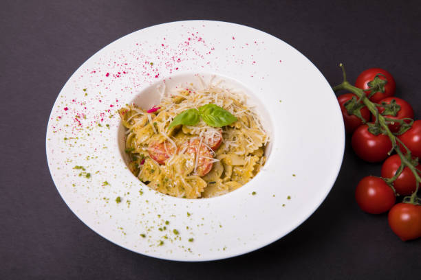 istock Carbonara pasta in a plate on a black background with cherry tomatoes 1463725561
