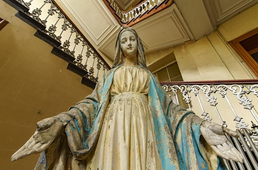 A low angle view of the statue of Virgin Mary with her palms showing in the room