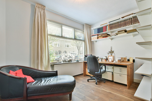 An office room in an apartment with a desk, chair, and bookshelves