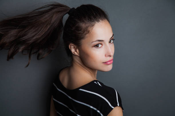 young pretty woman portrait with ponytail in motion studio shot