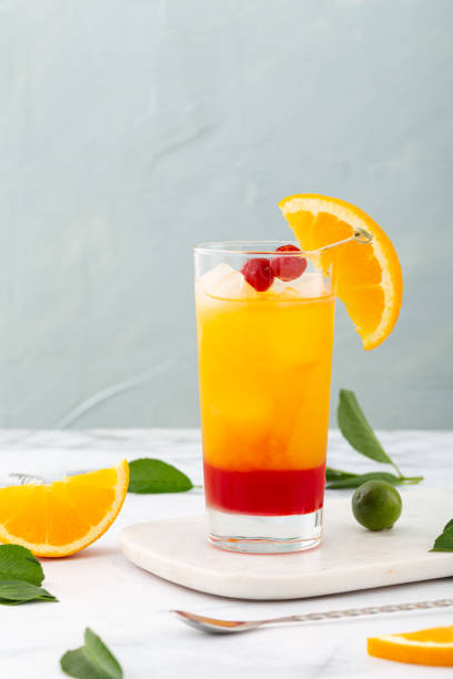 Tequila sunrise cocktail on a white table with sliced oranges Fresh Tequila sunrise cocktail on a white table with sliced oranges tequila sunrise stock pictures, royalty-free photos & images