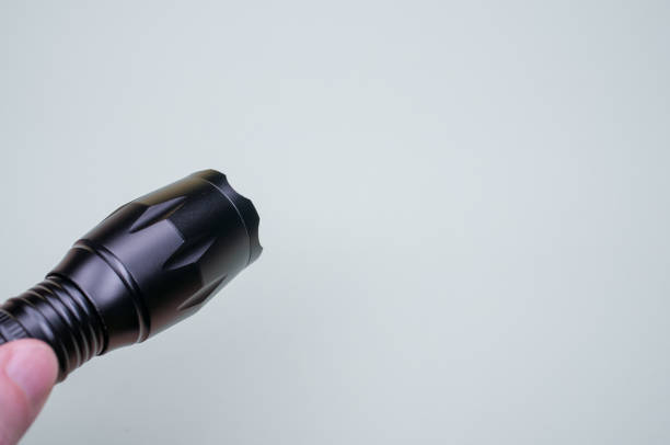istock Closeup of a black flashlight on the gray background. 1463735508