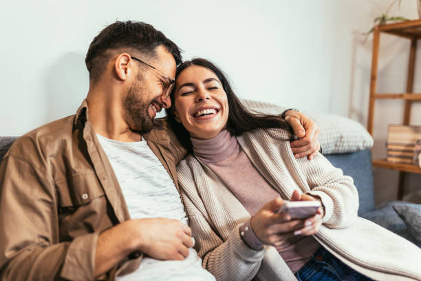 istock Happy young Caucasian couple relax on cozy sofa at home hugging 1463735711